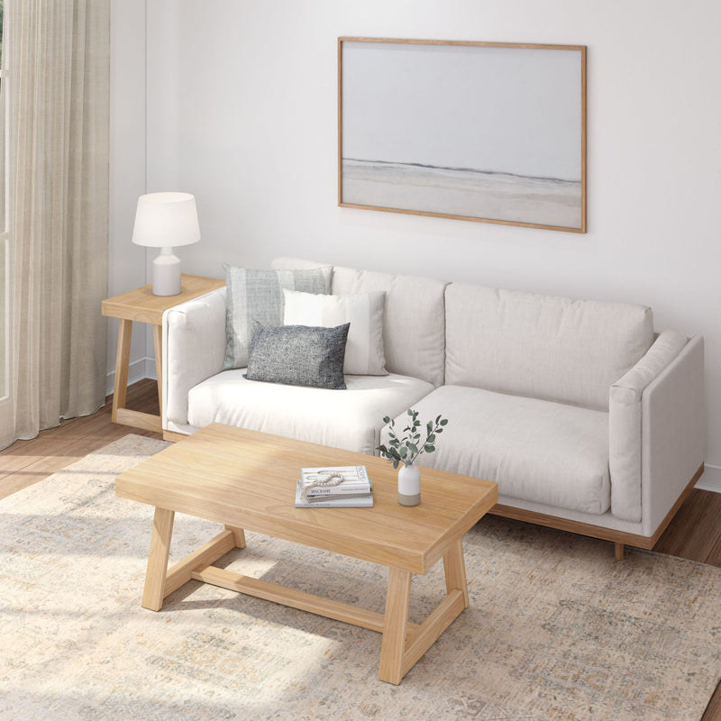 Modern living room with a beige sofa, wooden coffee table, and decorative wall art.