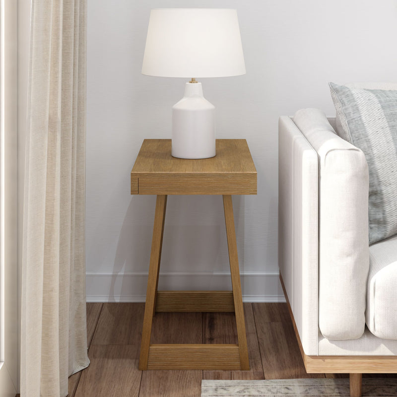 Modern living room with wooden side table and white table lamp next to a beige sofa.