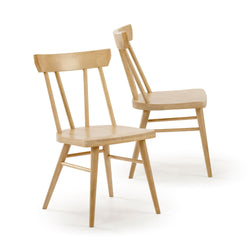 Two natural wood dining chairs with spindle backs on a white background.