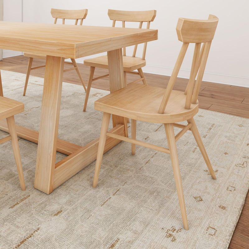 Modern wooden dining table set with natural oak finish chairs on a textured rug.