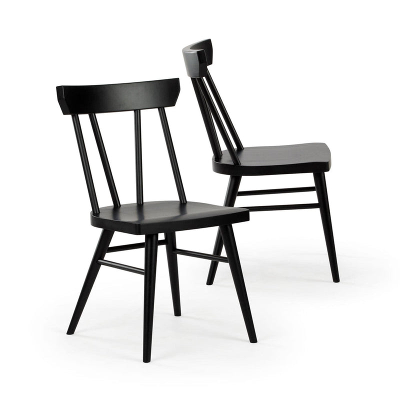 Two black wooden spindle-back dining chairs with matte finish, modern minimalist Scandinavian design, solid wood seats and tapered legs on white background