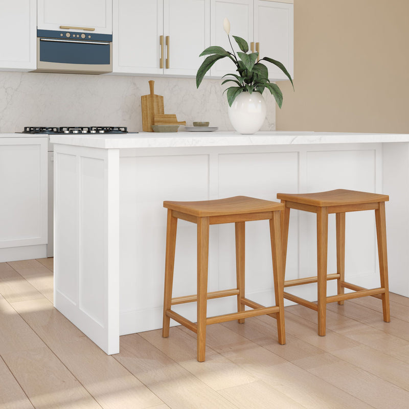Modern kitchen interior with white cabinets, marble countertop, wooden bar stools, and a potted plant for an elegant design.