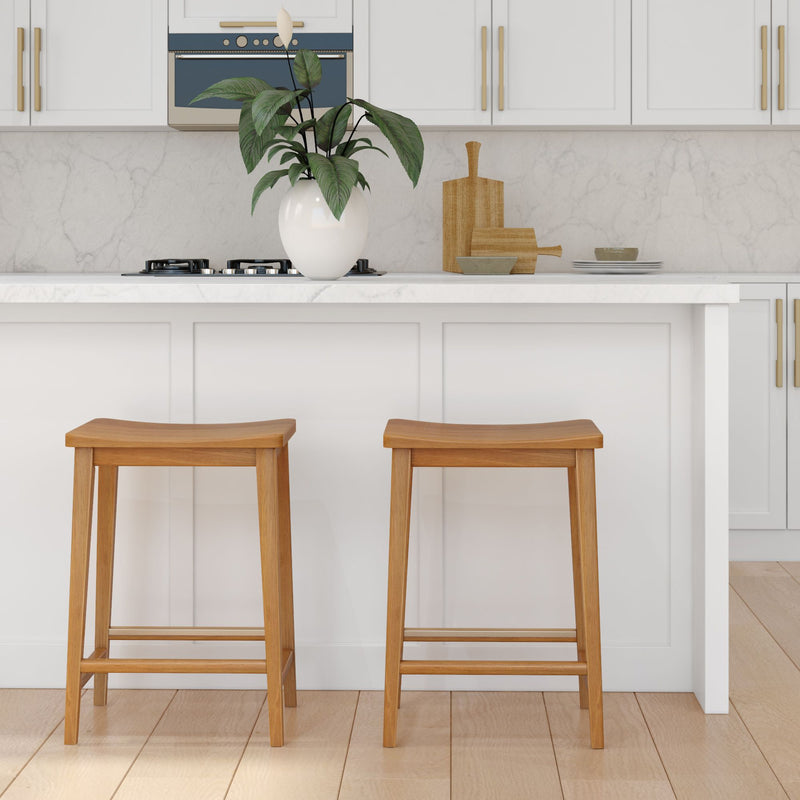 Modern kitchen interior with wooden stools, marble countertop, and elegant white cabinetry.