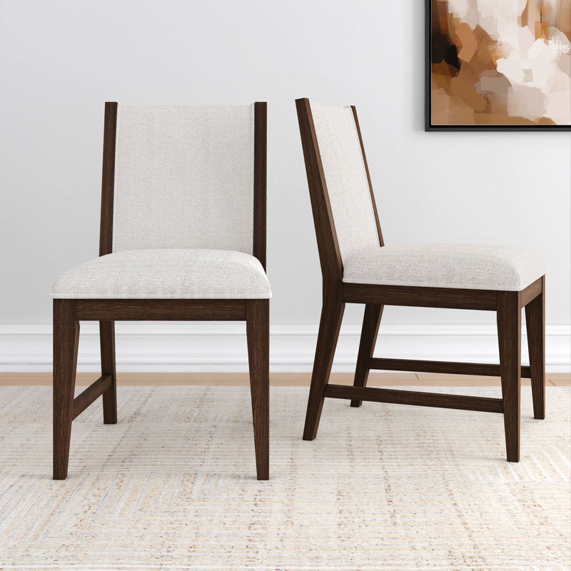 Set of two modern dining chairs with dark wood frame and beige upholstery, on light textured rug in minimalist room.
