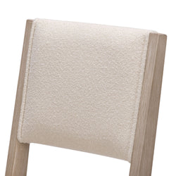 Close-up of beige textured upholstered dining chair back with light oak wood frame