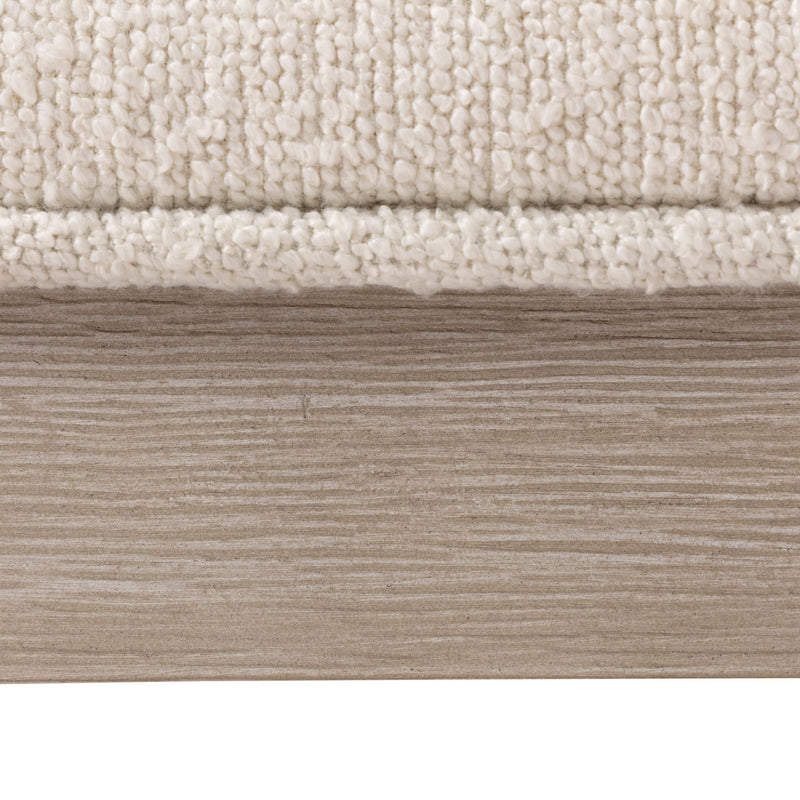Close-up of cream loop-pile area rug edge on light oak wood plank floor — neutral beige rug texture for living room decor
