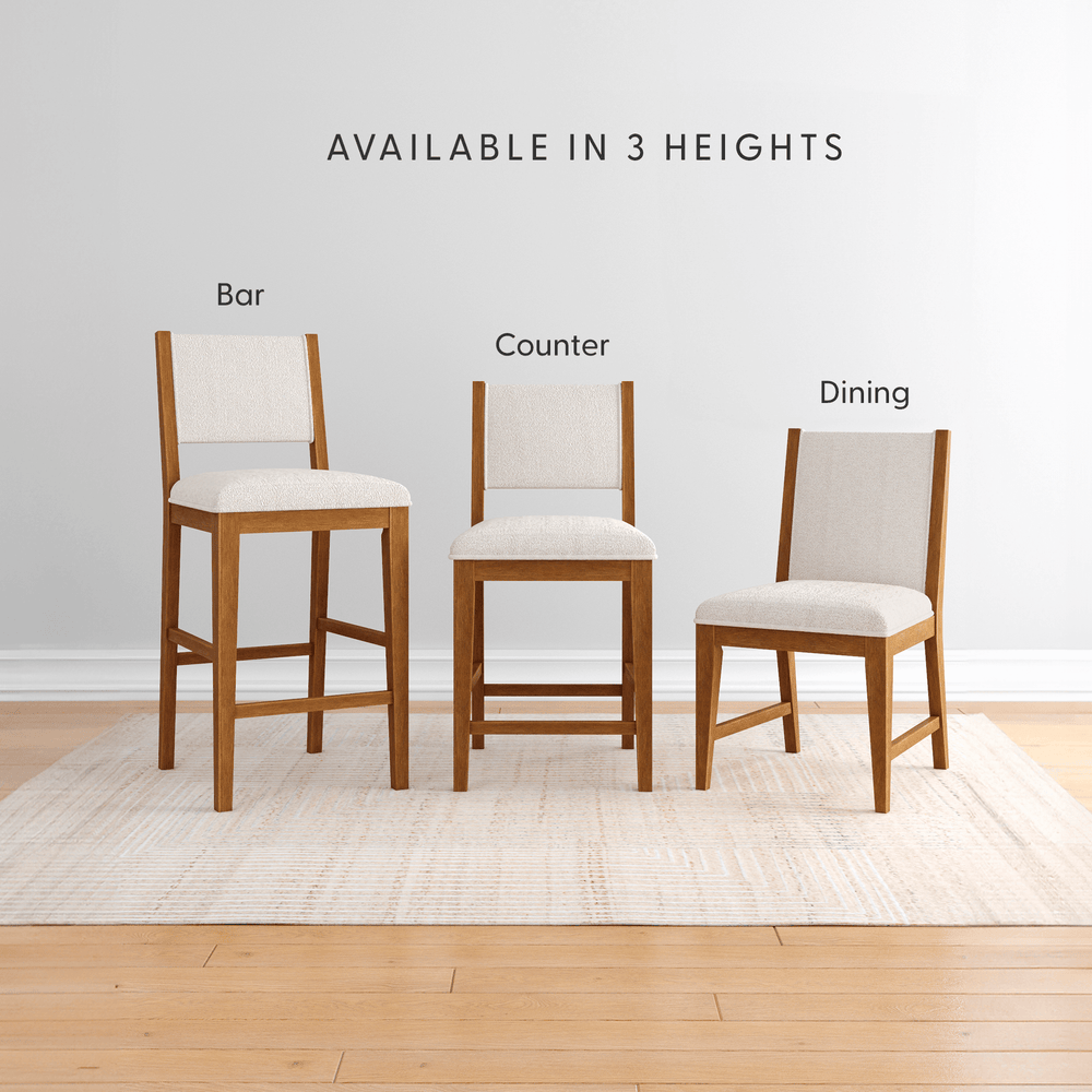 Wooden dining, counter, and bar height chairs with white cushions displayed on a rug.