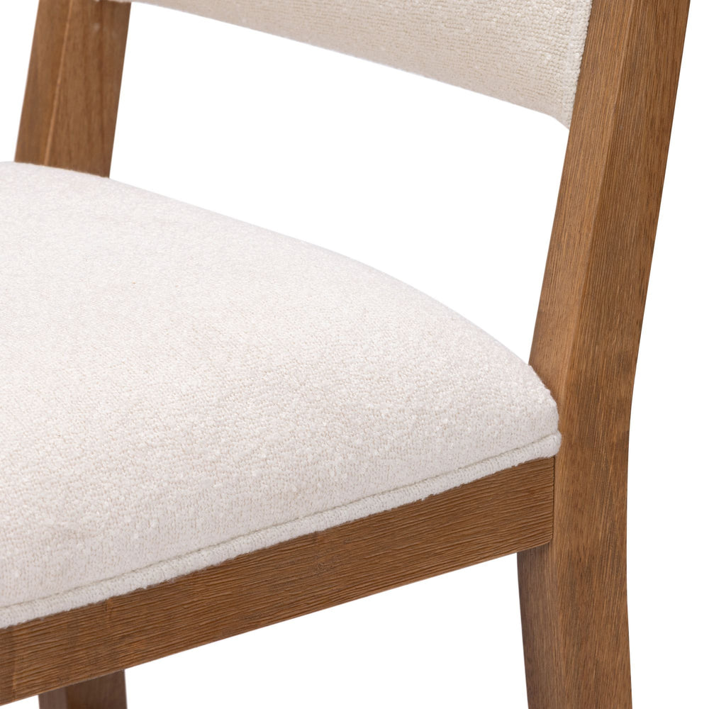 Wood and linen dining chair with soft white cushion and wooden frame.
