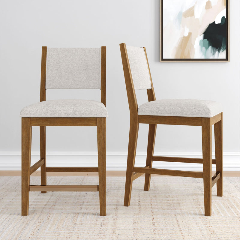 Two wooden bar stools with cushioned seats placed on a neutral rug in a modern dining space.