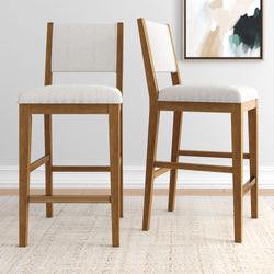 Two modern wooden counter stools with white cushioned seats in a contemporary home setting.