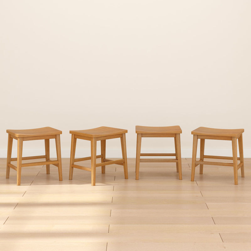 Set of four light wood stools arranged in a row on a pale hardwood floor against a neutral beige wall