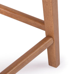 Close-up of mid-century modern solid wood chair leg and rounded stretcher joint with natural finish