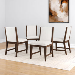Mid-century modern dining chairs with white upholstery and dark wood frames on a light rug in a minimalist room.