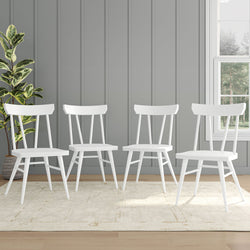 Set of four modern white dining chairs in a stylish grey-walled room with natural light.