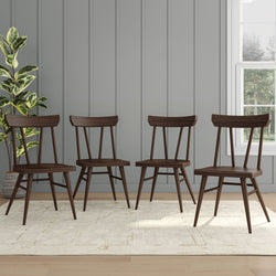 Four modern wooden dining chairs on a light carpet in a stylish room with paneled walls and a potted plant.