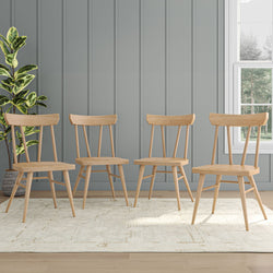 Four modern wooden dining chairs with a plant in a stylish, minimalist room featuring paneled walls and a light rug.