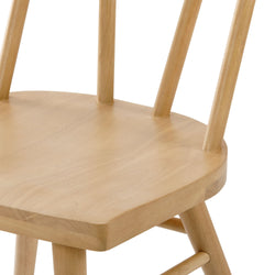 Natural wood dining chair with spindle back design.
