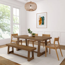 Modern dining room with wooden table, chairs, and bench set on a light area rug, featuring a stylish woven pendant light and contemporary wall art.