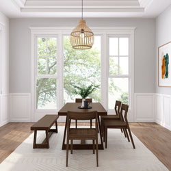 Bright modern farmhouse dining room with walnut wood table and bench, woven rattan pendant light, large windows and green plant centerpiece