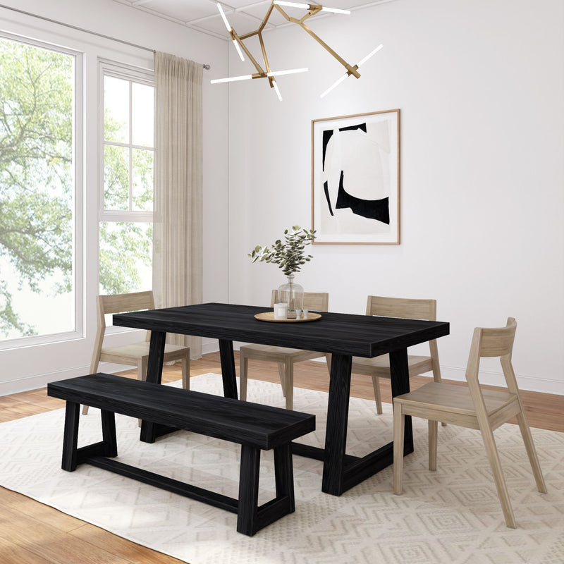 Modern dining room with black table and bench, light wood chairs, abstract wall art, and brass chandelier.