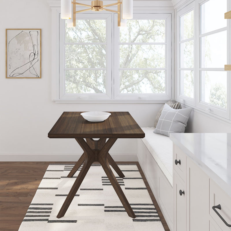 Cozy dining nook with a modern wooden table, white built-in bench with patterned cushions, contemporary lighting, and large windows.