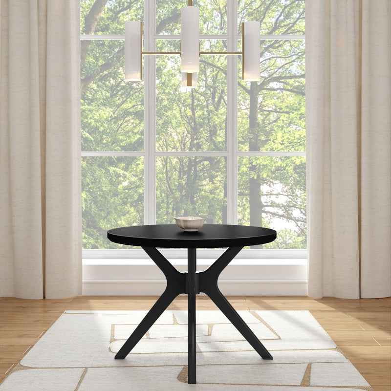Modern round black table in a bright room with large windows and curtains.