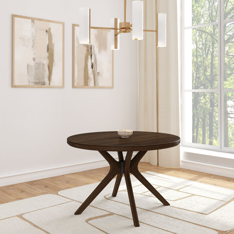 Modern dining room with round wooden table and elegant chandelier.