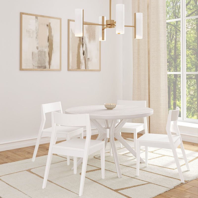 Modern dining room with white round table, four white chairs, and abstract wall art.