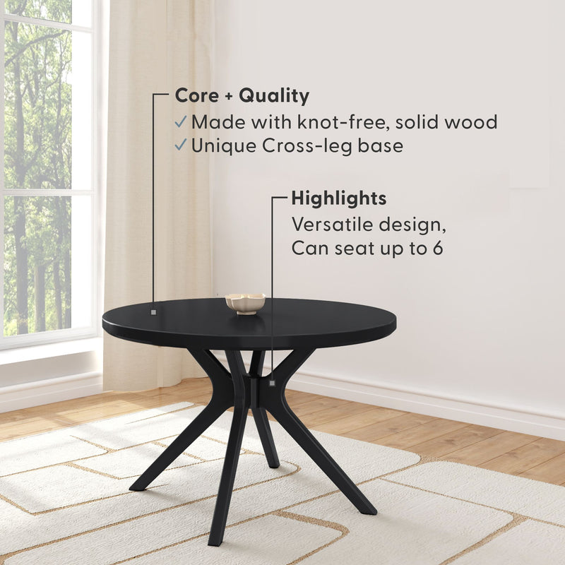 Black round solid-wood dining table with unique cross-leg base in modern dining room, seats up to 6