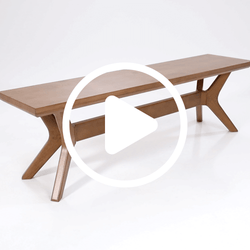 Mid-century modern wooden bench with unique leg design on white background.