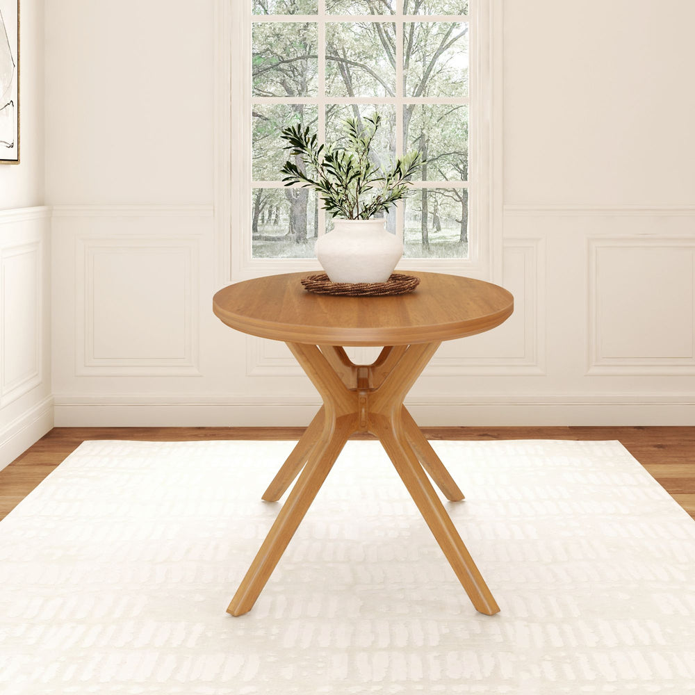Round wooden dining table with vase in bright, elegant room.