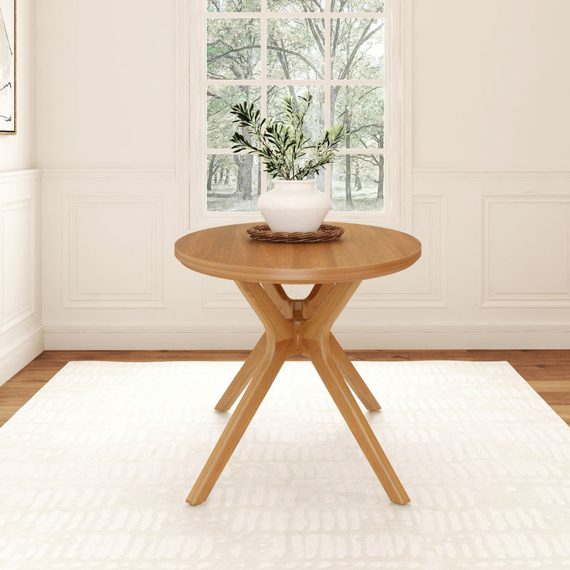 Round wooden dining table with vase in minimalist dining room setting.