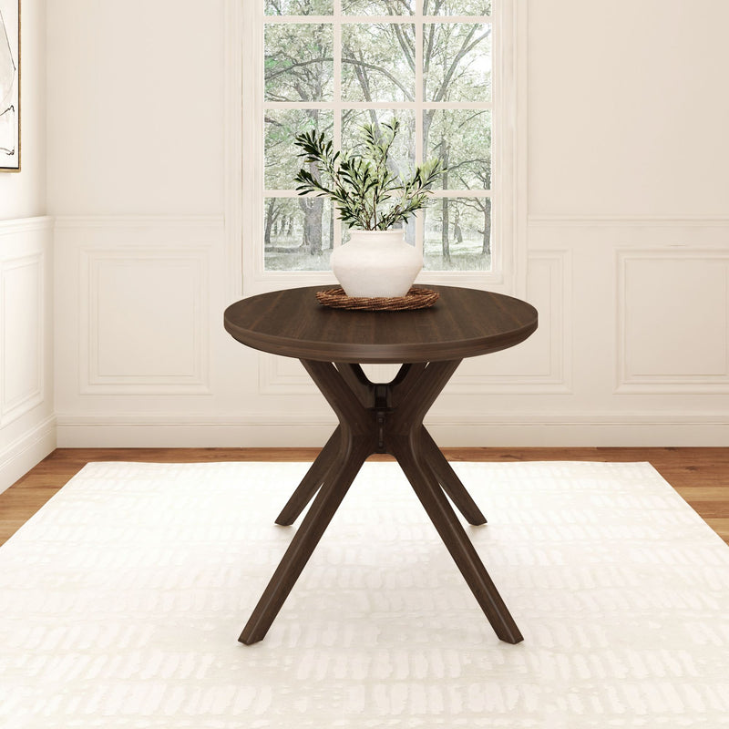 Round wooden dining table with plant centerpiece in modern bright dining room.