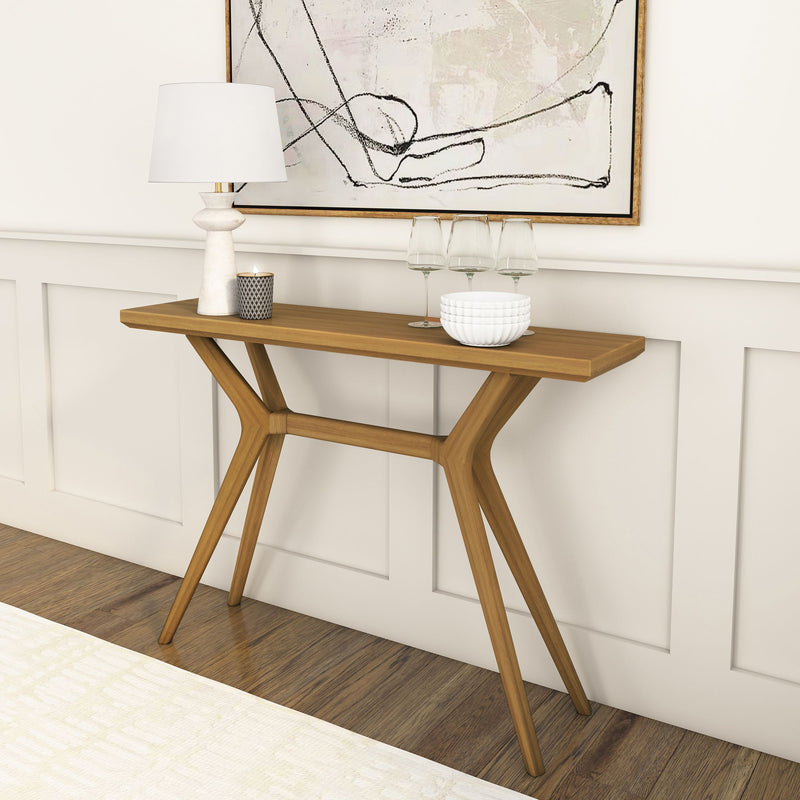 Modern wooden console table with lamp and decor, against white paneled wall in living room.