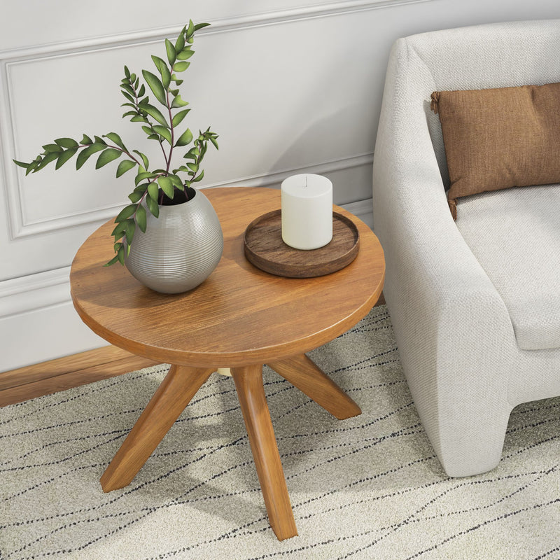 Modern living room with a wooden side table, decorative plant, and candle next to a beige sofa and brown cushion.