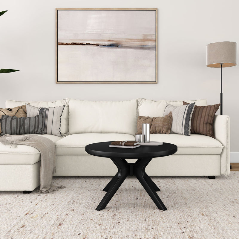 Minimalist living room with white sectional sofa, abstract wall art, and modern black coffee table.