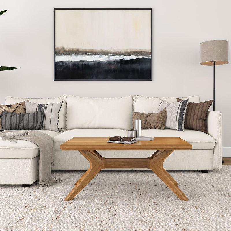 Modern living room with white sofa, wooden coffee table, floor lamp, and abstract wall art.