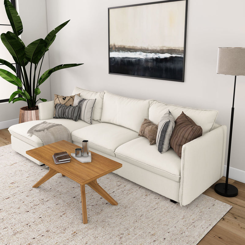 Contemporary living room with white sectional sofa, wooden coffee table, lush plant, and modern art.