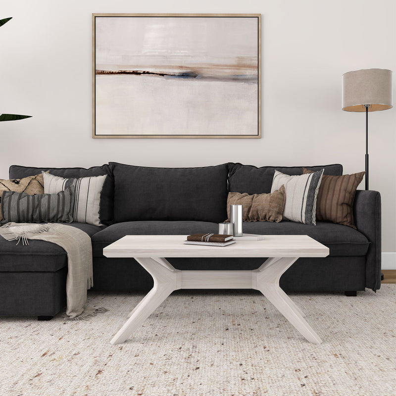 Modern living room with dark grey sectional sofa, abstract wall art, and beige floor lamp.