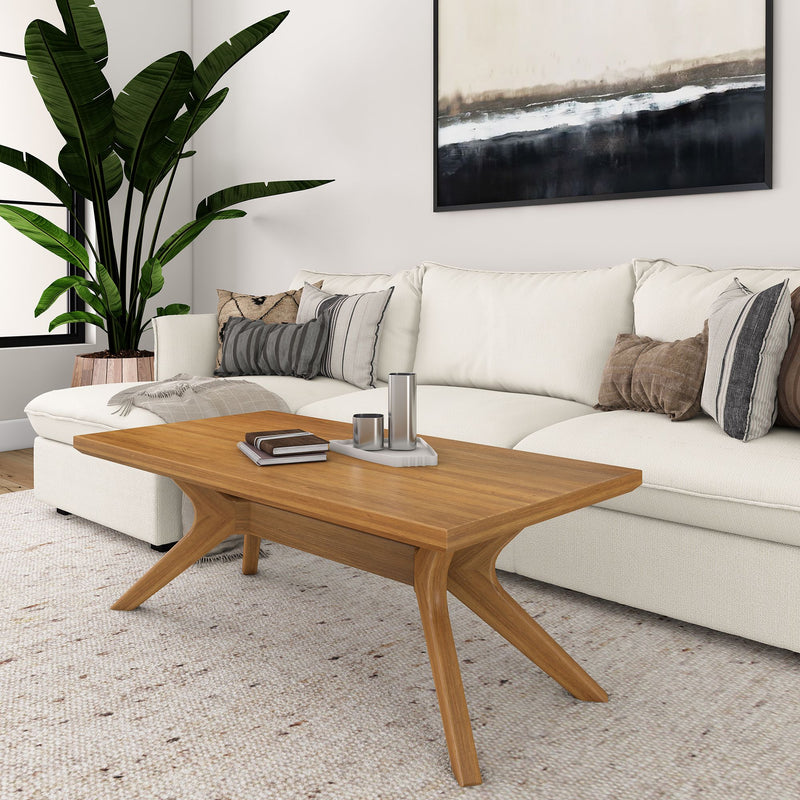 Modern living room with a white sofa, wooden coffee table, large green plant, and abstract wall art.
