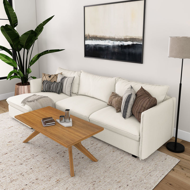 Modern living room with white sofa, wooden coffee table, large plant, and abstract wall art.