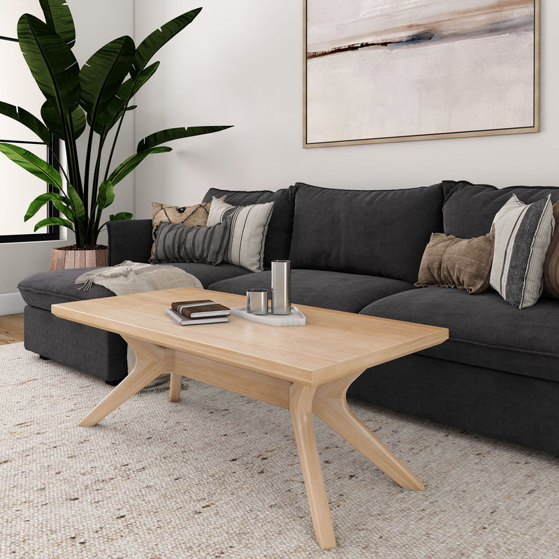 Modern living room with dark gray sofa, stylish wooden coffee table, indoor plant, and abstract wall art.