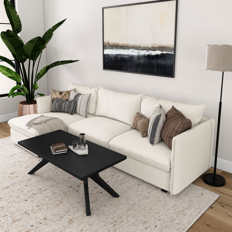 Stylish modern living room with white sofa, black coffee table, and decorative pillows.