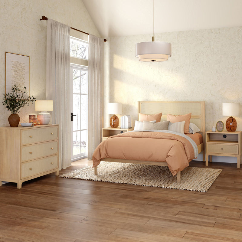 Cozy modern boho bedroom with light wood bed and dressers, peach duvet, woven area rug, wood flooring and sunlit window with sheer curtains