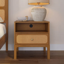 Mid-century modern wooden nightstand with woven rattan drawer, ceramic table lamp and decorative bowl in a neutral bedroom
