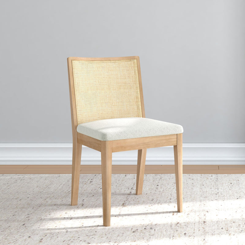Elegant wooden chair with light upholstery on a textured rug in a minimalist room setting.