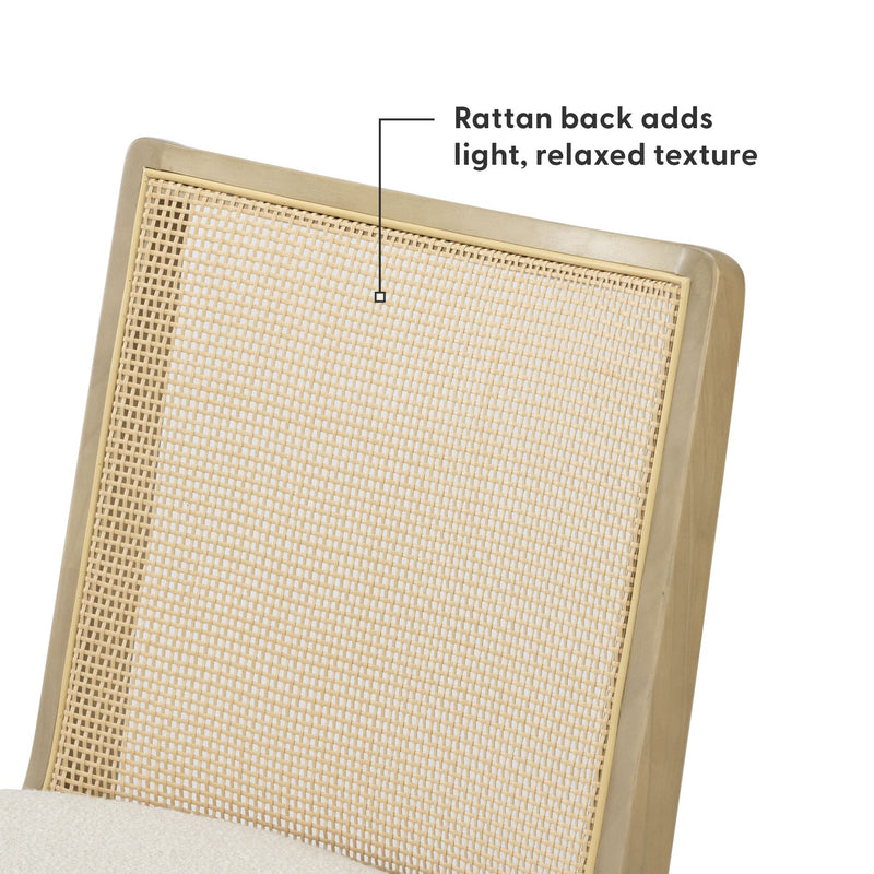 Close-up of a mid-century modern dining chair with natural woven rattan caned back, light wood frame, and cream upholstered seat