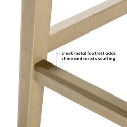 Close-up of light wood bar stool leg with brass-finish metal footrest showing sleek, scratch-resistant finish
