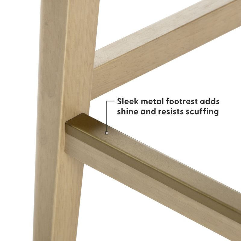 Close-up of light wood bar stool leg with brass-finish metal footrest showing sleek, scratch-resistant finish