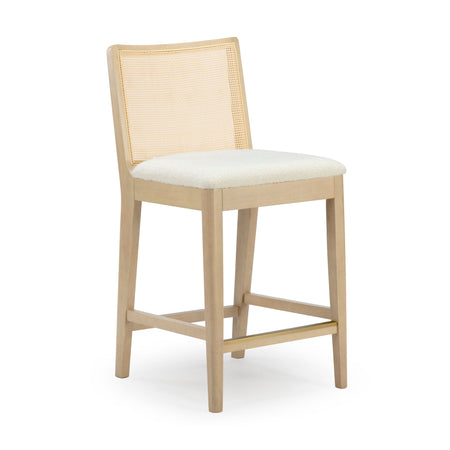 Light wood counter-height stool with woven cane back, cream upholstered seat and brass-accent footrest for modern kitchen island seating